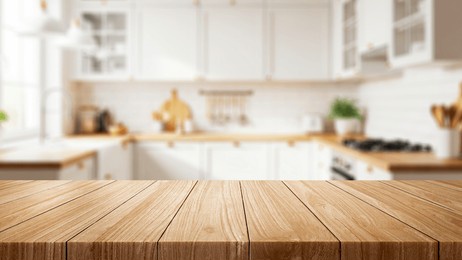 empty wooden table placed in front of a kitchen with blurred light and modern wooden counter background. minimal decoration, suitable for displaying food or decorating the house.