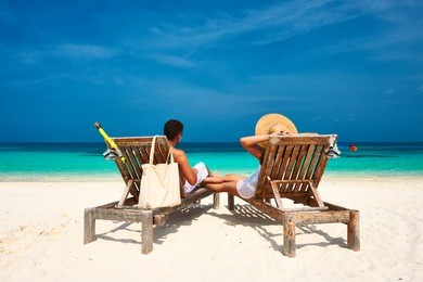 couple in white relax on a tropical beach at maldives