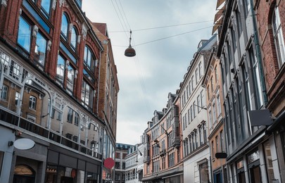 exterior urban street with vintage european building, large window and hanging lamp in shopping area at central of copenhagen, denmark