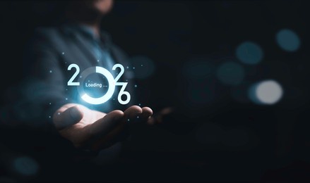 businessman holding virtual downloading 2026 number with blue bokeh background and copy space for merry christmas and happy new year concept.