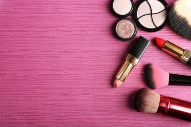 set of colorful cosmetics on pink wooden table background