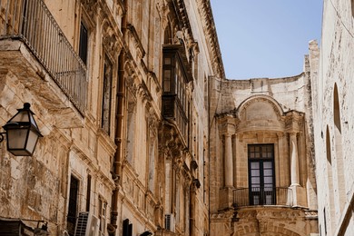 
a typical maltese street with its distinctive limestone and british-influenced balcony