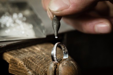 craft jewelery making. ring repairing. putting the diamond on the ring. macro shot.