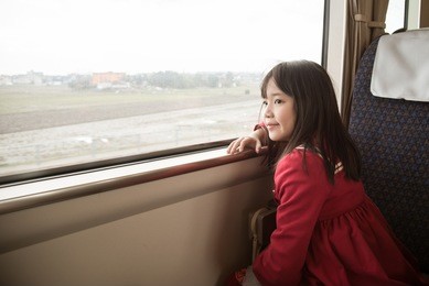 little asian girl looking through window. she travels on a train,vintage filter