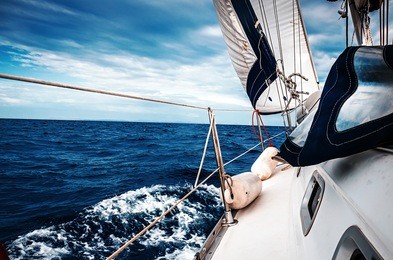 the white sails of yachts on the background of sea and sky in the clouds