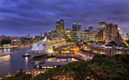 sydney harbour and city cbd at sunset with ocean liner at overseas terminal illuminated with lights