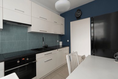 kitchen interior with modern household appliances for cooking at home. a residential property with a built-in oven, stove, and refrigerator. home improvement and renovation design ideas.