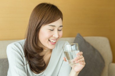asian woman drinking juice in the living room