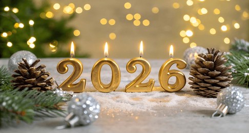 four golden candles shaped like the numbers 2026