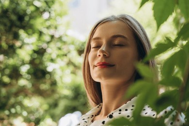 young beautiful woman enjoying fresh air in green park. natural beauty concept