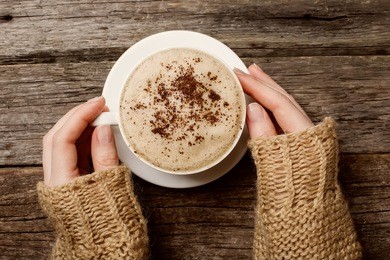 woman holding hot cup of coffee