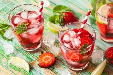 refreshing summer drink with strawberry in jug and glasses on the vintage wooden table