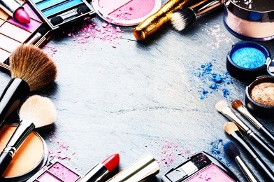 colorful frame with various makeup products on dark background