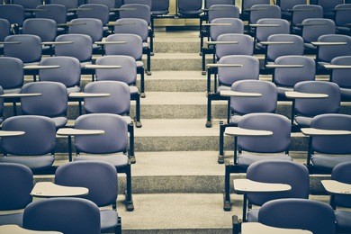 lecture chairs in a class room with stair path in the middle of a class