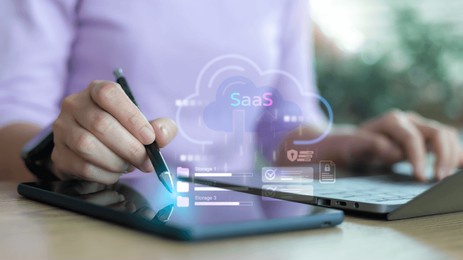 business person using tablet and laptop with saas cloud computing icon for digital data storage, online service, and modern software as a service technology concept.