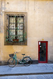florence, italy: oltrarno district urban street view with a typical house window and door and a bicycle with matching colors