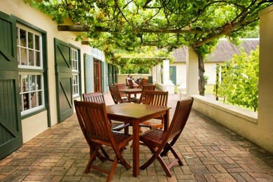 tables on terrace covered by grape vine. shot near stellenbosch and cape town, south africa.