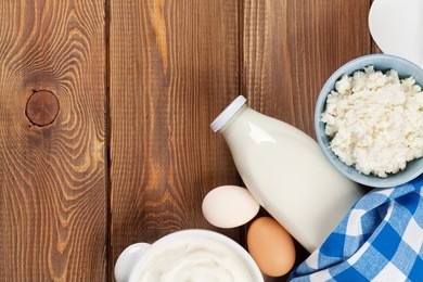 dairy products on wooden table. sour cream, milk, cheese, egg, yogurt and butter. top view with copy space