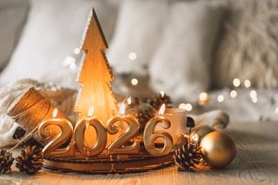decorative candles and a small christmas tree create a cozy scene celebrating the new year in winter 2026