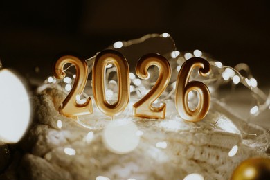 decorative candles and a small christmas tree create a cozy scene celebrating the new year in winter 2026