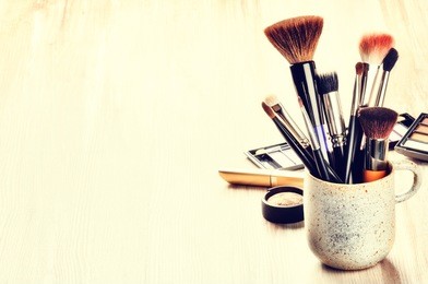 various makeup brushes on light background with copyspace