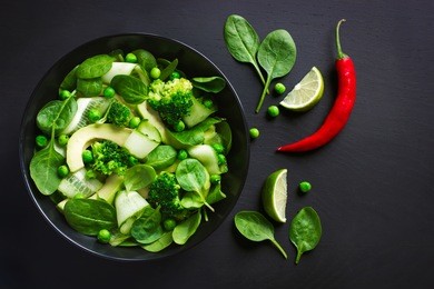 healthy food. fresh green salad on black background, top view