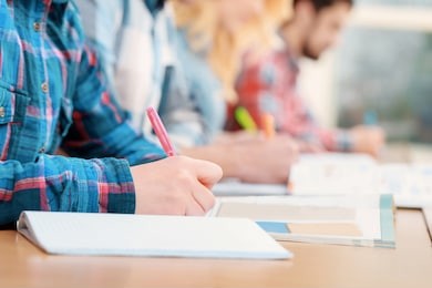 exams. cropped view of students writing a test in their exercise books