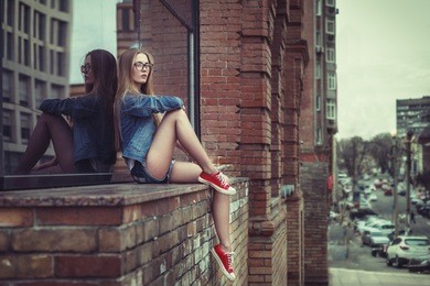outdoor lifestyle portrait of pretty young sitting girl, wearing in hipster swag grunge style urban background. retro vintage toned image, film simulation.