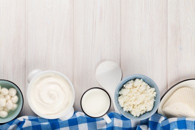 dairy products on wooden table. sour cream, milk, cheese, yogurt and butter. top view with copy space