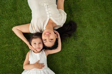 happy family of two lying on the grass, view from above