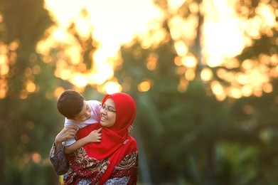 happy mother playing with her son in the park. toned image. selective focus.