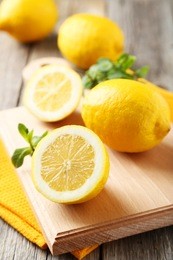lemons on cutting board on grey wooden background
