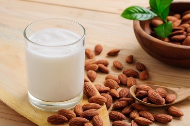 almond milk with almond on a wooden table