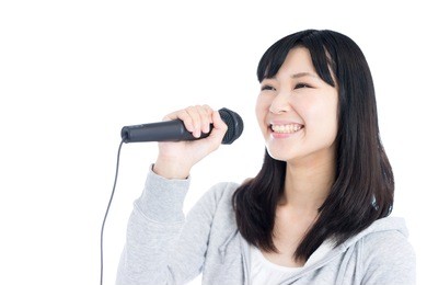 young asian woman singing with microphone, isolated on white background