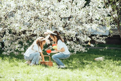 easter egg hunt concept. easter celebration. children gathering colorful eggs in basket. happy holiday.