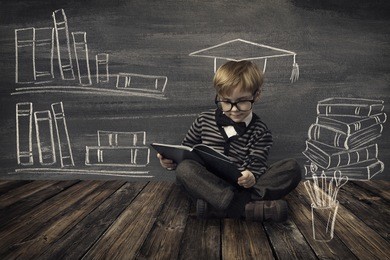 child little boy in glasses reading book over school black board with chalk drawing, kids preschool development, children education concept