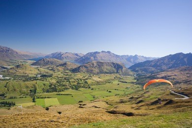 paraglider soaring in the mountains, new zealand
