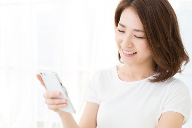 young attractive asian woman  to see a smart phone