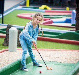cute smiling little girl playing golf