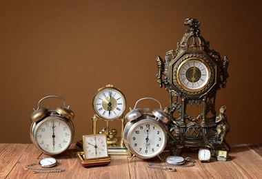 old clocks, alarm clocks and handheld clocks on the table