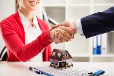 two business people shaking hands as successful agreement in real estate agency office. concept of housing purchase and insurance. 
