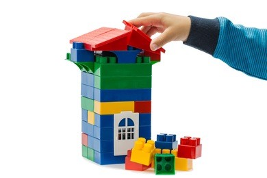 game constructor and the hand of of the child isolated on white background.this is not a lego, given manufacturer, different form and fixation, size