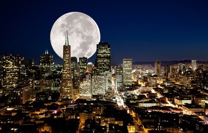 a full moon over an urban metropolis