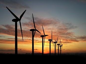 wind turbine farm over sunset