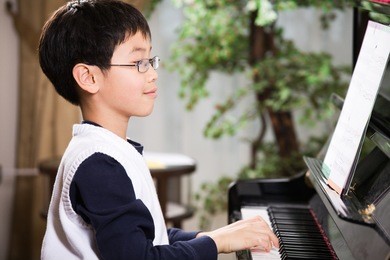 a shot of an asian boy playing piano