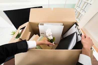 high angle view of businesswoman packing personal belonging in box
