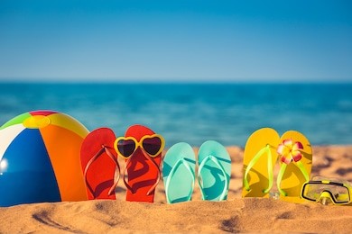 flip-flops, beach ball and snorkel on the sand. summer vacation concept