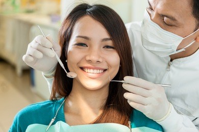 portrait of smiling asian woman sitting at the dentist