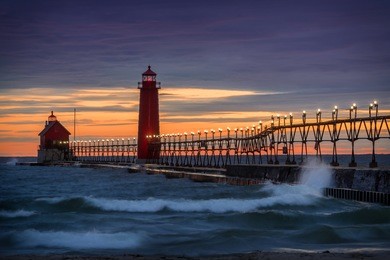 sunset at the grand haven south pierhead inner light with entrance light in background in grand haven state park in grand haven, michigan