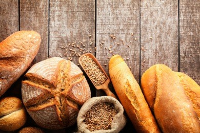 assortment of baked bread on wooden table background